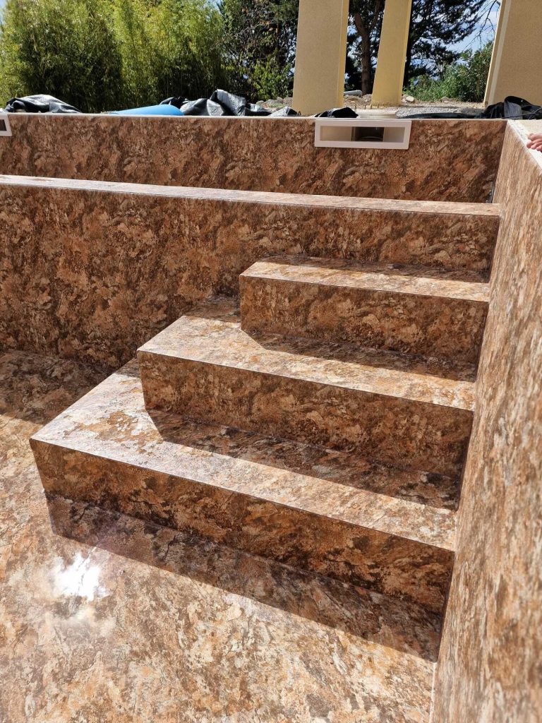 Escalier de piscine avec membrane armée texturée effet pierre